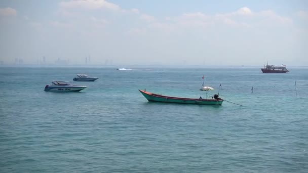 パタヤ島ラーン島霞の中のパタヤの街を背景に 海でのタイのモーターボート 毎年ビーチ 2017年7月12日タイ パタヤ — ストック動画
