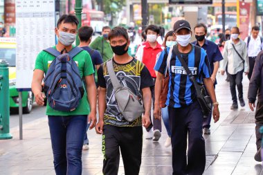 Bangkok 'taki maskeli insanlar şehir caddesi boyunca yürüyorlar. Tayland Bangkok Mart 2020