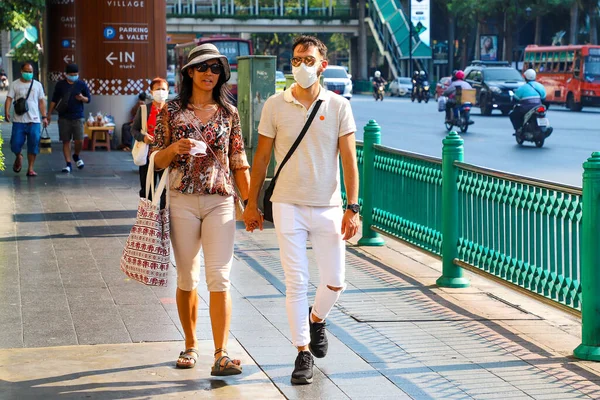 Bangkok 'taki maskeli insanlar şehir caddesi boyunca yürüyorlar. Tayland Bangkok Mart 2020