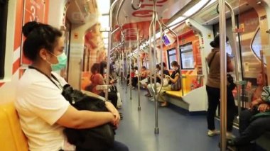 BTS Skytrain yolcuları Bangkok 'ta bir metro vagonunda, tıbbi maskeli insanlar. Tayland Bangkok Mart 2020