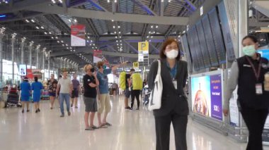Bangkok Suvarnabhumi havaalanı yolcuları kalkış kuruluna bakın, Coronavirus maskeli insanlar. Tayland Bangkok Mart 2020