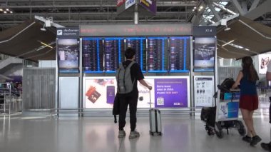 Bangkok Suvarnabhumi havaalanı yolcuları kalkış kuruluna bakın, Coronavirus maskeli insanlar. Tayland Bangkok Mart 2020