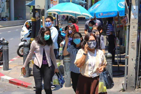 Sağlık maskeli Bangkok 'lular şehirde yürüyor. Tayland Bangkok Mart 2020
