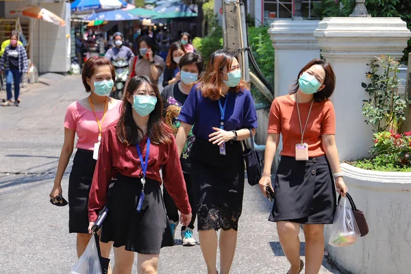Sağlık maskeli Bangkok 'lular şehirde yürüyor. Tayland Bangkok Mart 2020