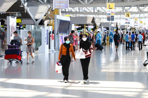 Bangkok Suvarnabhumi havaalanı yolcuları kalkış terminalinde, Coronavirus maskeli insanlar. Tayland Bangkok Mart 2020
