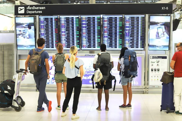 Bangkok Suvarnabhumi havaalanı yolcuları kalkış kuruluna bakın, Coronavirus maskeli insanlar. Tayland Bangkok Mart 2020