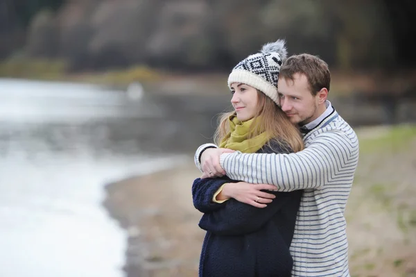 Romantic teenage couple in autumn park on the river bank — Stock Photo, Image