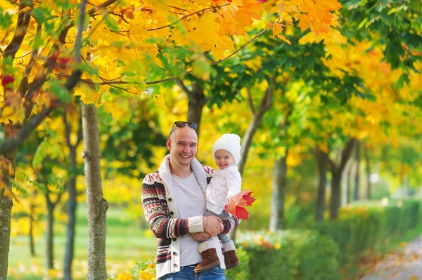 Padre con una hija pequeña está en el parque de otoño — Foto de Stock