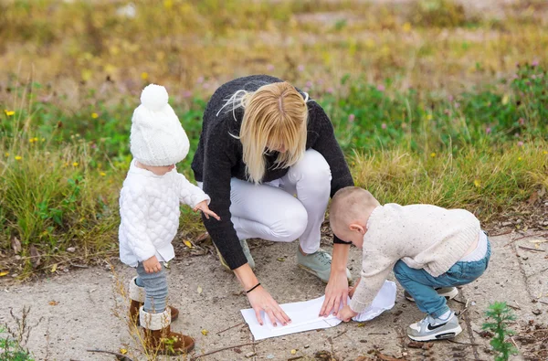 Matkę i jej dwoje dzieci, które są zaangażowane w kreatywność na zewnątrz. — Zdjęcie stockowe