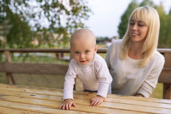 The little girl is on a wooden table. — Stock Photo, Image