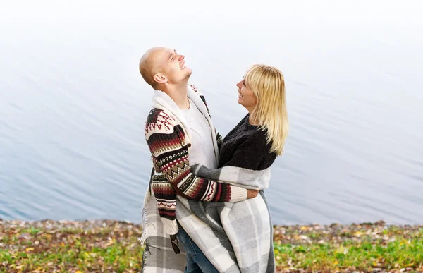 Couple souriant étreignant sur fond d'eau — Photo