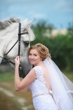 Gelin yanındaki çim üzerinde bir güzel safkan at duran.