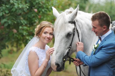 Gelin ve damat yanında güzel bir safkan at çim.