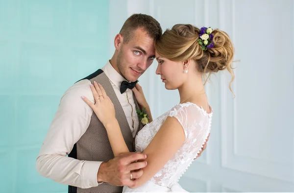 美しい白い部屋でポーズをとってエレガントな新郎新婦 — ストック写真