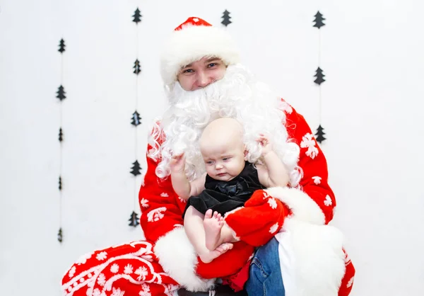 Weihnachtsmann mit Baby-Mädchen im weißen Zimmer. — Stockfoto
