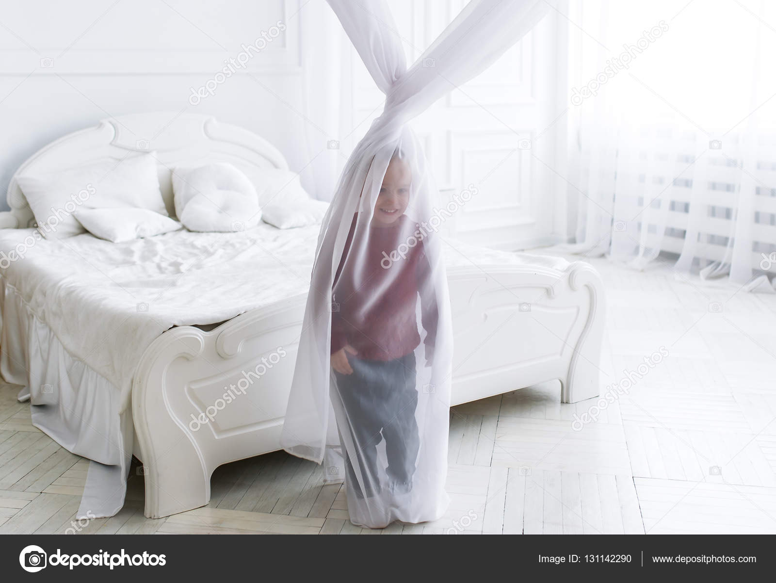 der kleine junge hat sich für einen vorhang im großen hellen