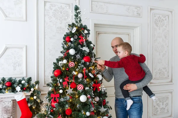 Padre e hijo están decorando el árbol de Navidad — Foto de Stock