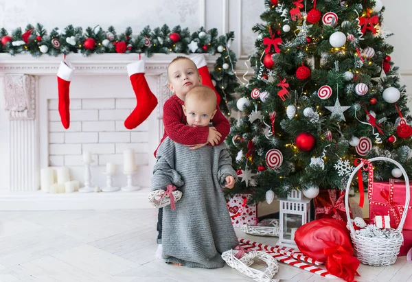 El hermano abraza a la hermanita en Navidad . — Foto de Stock