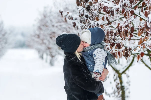 Motherkissing hennes dotter utomhus på vintern — Stockfoto