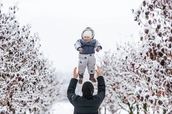 Glücklicher Vater wirft seinen kleinen Sohn an einem Wintertag hin — Stockfoto