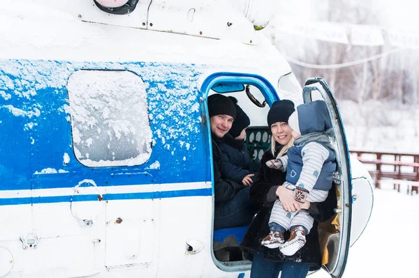 Pais com crianças se preparam para voar de helicóptero em tempo de neve . — Fotografia de Stock