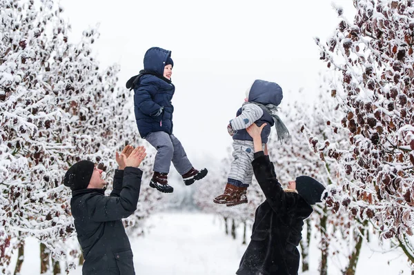 Parents heureux vomit bébé fils et fille dans le parc d'hiver en plein air — Photo