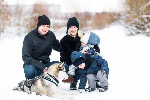 Parents avec deux enfants et chien en promenade en hiver — Photo