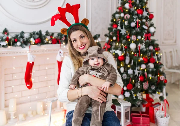 Joven madre con la niña sobre el fondo de un árbol de Navidad — Foto de Stock