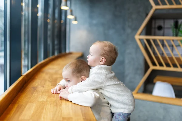 Hermano y hermana miran por la ventana . — Foto de Stock