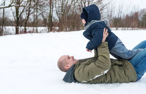 Glücklicher Vater und Sohn liegen im Schnee — Stockfoto