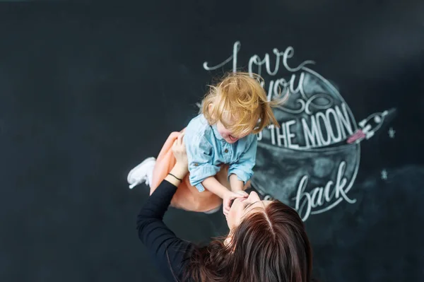 Ritratto di giovane madre con figlioletta sullo sfondo di una parete ornata . — Foto Stock
