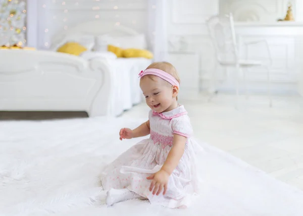 Doux bébé fille assis sur le sol dans la chambre blanche — Photo