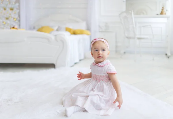 Doux bébé fille assis sur le sol dans la chambre blanche — Photo