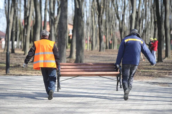 Zaměstnanci nesou lavice — Stock fotografie