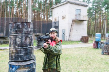 Kadın paintball oyuncu ile tehlikeli bak. Optik görüş arayan kadın