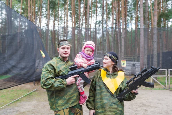 The young family plays laser tag. Beautiful young family portrait.