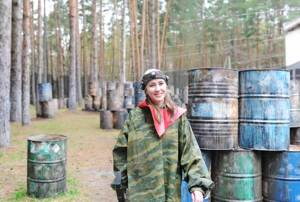 Portret van een jonge vrouw in camouflage met een geweer. Buitenshuis — Stockfoto