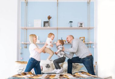 Anne, baba ve iki çocuk bir yatakta iyi eğlenceler. Hepsi bu neşeli.