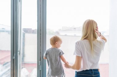 genç anne ile bebek pencereden