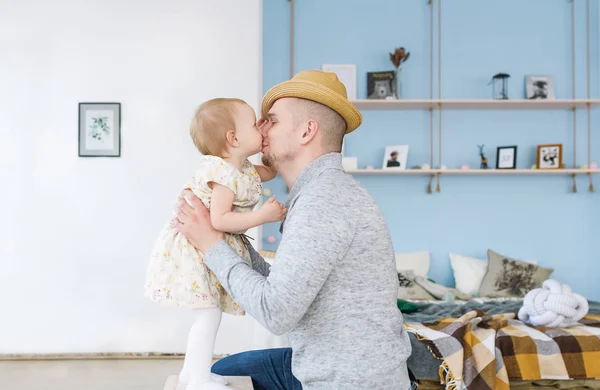 Красивый молодой отец целует свою милую маленькую девочку. Оба дома. — стоковое фото