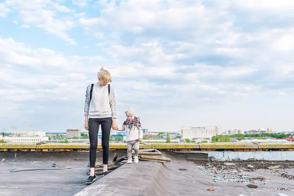 Mãe com pequena filha andando em um telhado da cidade . — Fotografia de Stock
