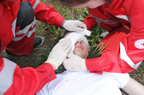 Paramedics giving first aid person after accident. Demonstrative exercises. — Stock Photo, Image