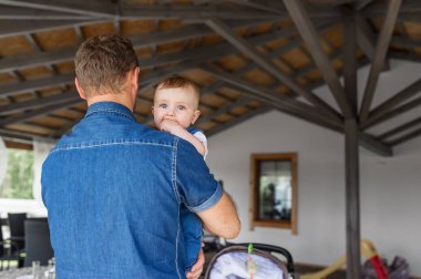 Şirin Bebek oğlu kollarında tutan genç Baba