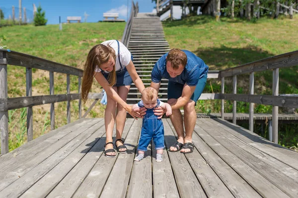 Padres sosteniendo a su pequeño hijo dando los primeros pasos —  Fotos de Stock