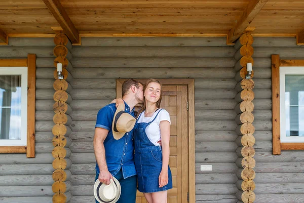 Κομψό ζευγάρι στέκεται ίσια μπροστά νέα ξύλινο σπίτι — Φωτογραφία Αρχείου