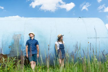 Hipster iki yüzleri bir şapka arkasında saklanıyor. Açık havada bir güzel güneşli yaz gününde oynarken