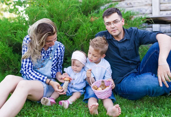 Jeune famille avec un panier de champignons dans le parc d'été . — Photo
