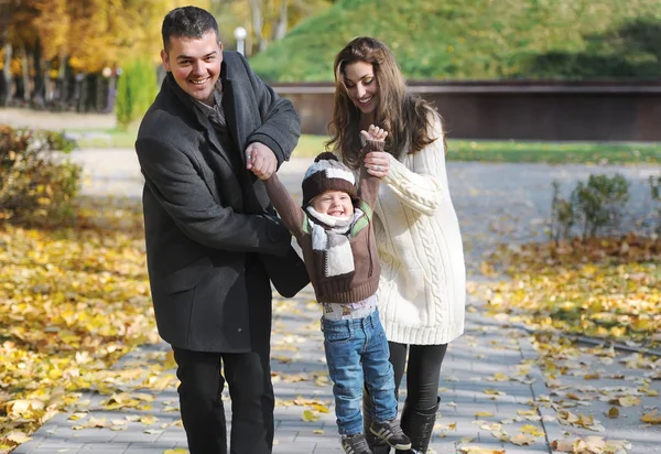 Feliz familia caminando y divirtiéndose en el parque de otoño — Foto de Stock