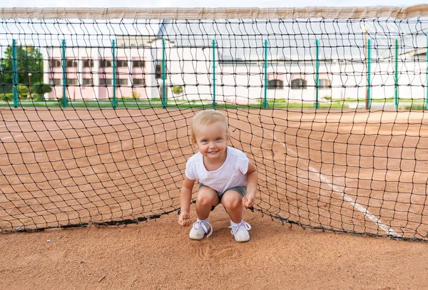 Małe słodkie dziewczyny w biały T-shirt na kort tenisowy. Portret uśmiechający się ładny dziecko. — Zdjęcie stockowe