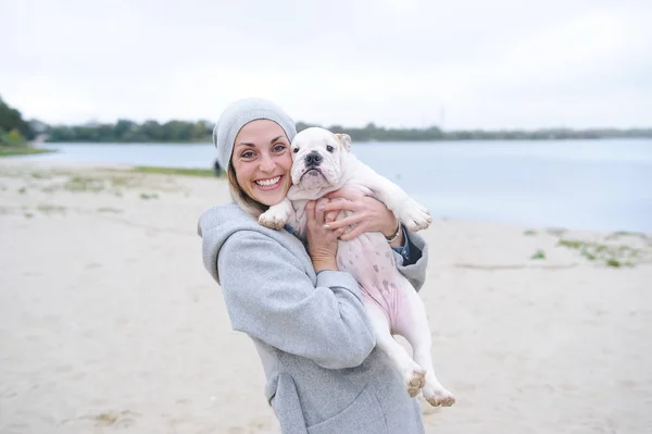 Valp en bulldog och dess ägare ung kvinna är de bästa vännerna. — Stockfoto